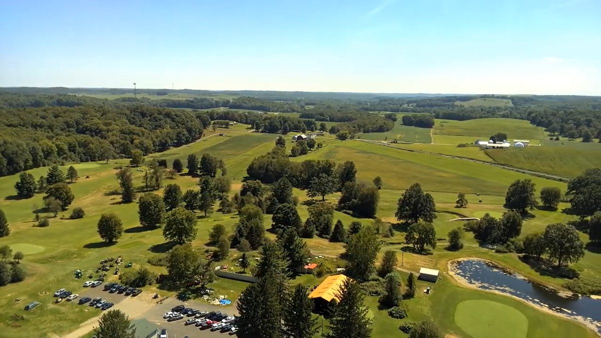 Aerial drone shot over a golf course and farmland